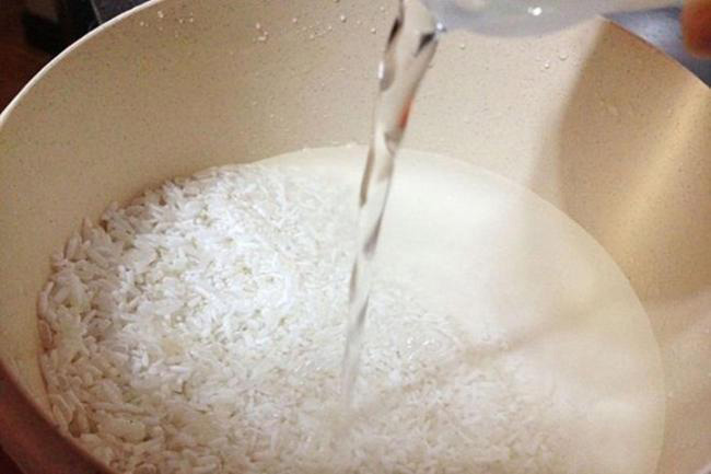 Đổ gạo vào nồi và thêm nước tương ứng, đong gạo nấu cơm