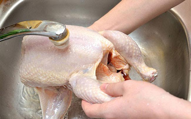 Sau khi chà xát muối, gừng đem gà đi rửa sạch với nước 